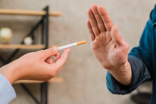 Man refusing cigarettes offered by his female colleague Free Photo