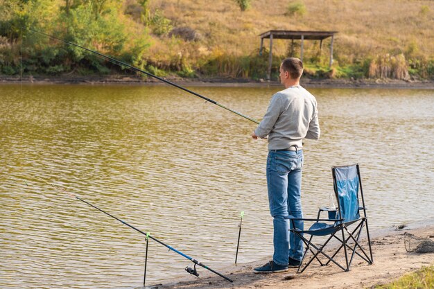 Premium Photo | Man relaxing and fishing by lakeside