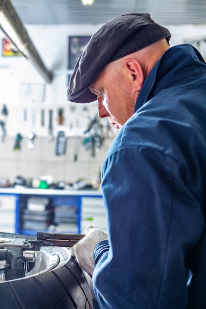 Premium Photo | Man repairing motorcycle tire with repair kit, tire