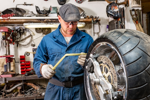 Premium Photo | Man repairing motorcycle tire with repair kit