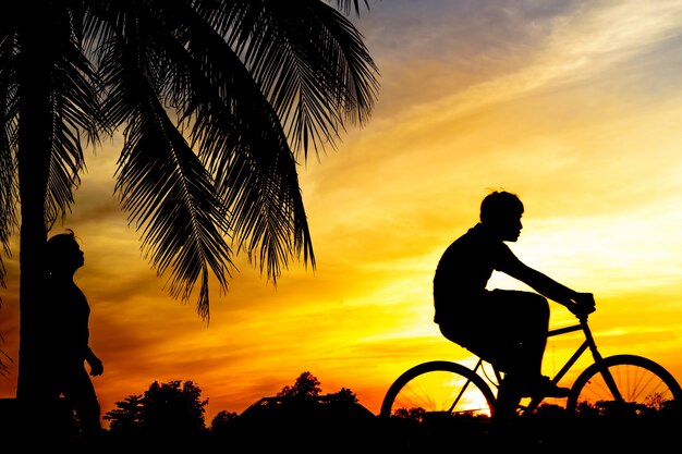 Premium Photo A Man Rides Bike At Sunset