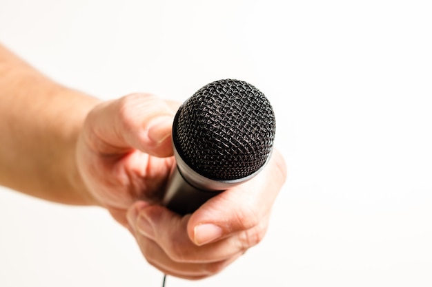 Premium Photo | A man's hand holding a black microphone. concept of ...