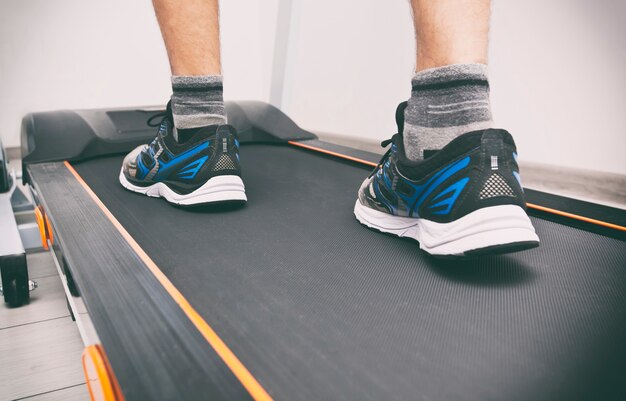 Premium Photo | The man's legs in sneakers on the treadmill