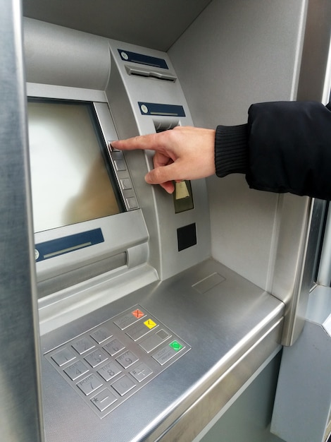 Man's using the atm machine with cash cards and entering ...