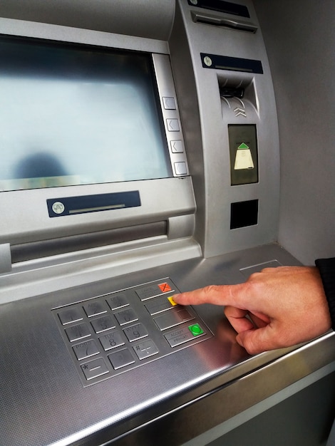 Man's using the atm machine with cash cards and entering ...