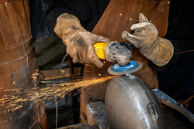 Premium Photo | Man sanding metal to make a metal object