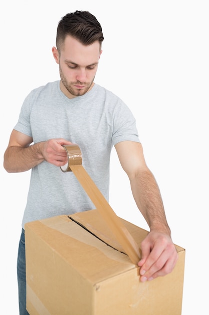 Download Man sealing cardboard box with packing tape | Premium Photo