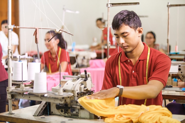 Premium Photo | Man sewing on a sewinghine at a clothing factory