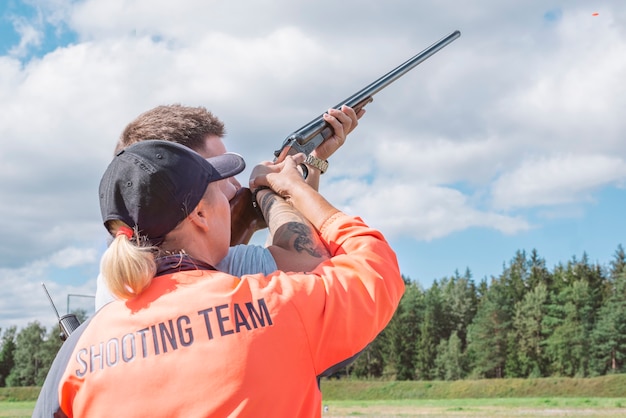 Premium Photo Man Shoots Plates With A Hunting Rifle In A Competition   Man Shoots Plates With Hunting Rifle Competition Supervision Instructor Concept Hunting Shooting Competition 392761 3896 