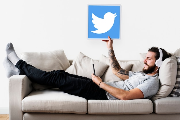Man showing a twitter icon Free Photo