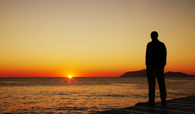 Premium Photo | Man silhouette on the sunset on sea pier