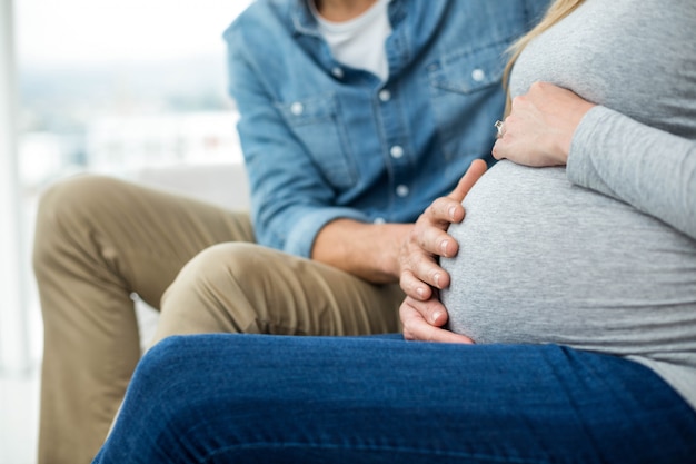 男はソファーに座っていたと妊娠中の梨花の胃を保持 プレミアム写真