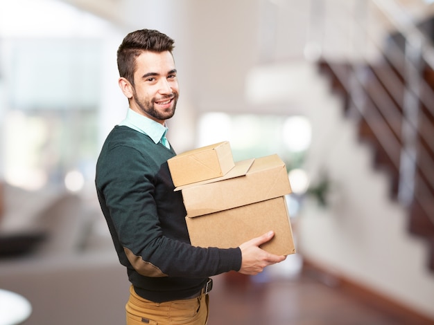 Man smiling with a lot of boxes Free Photo