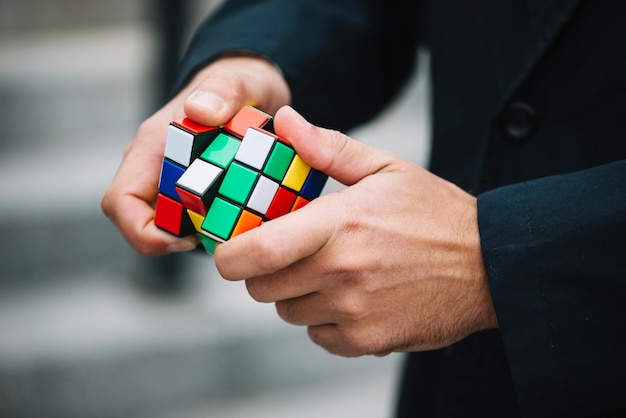 Man solving rubik's cube Photo | Free Download