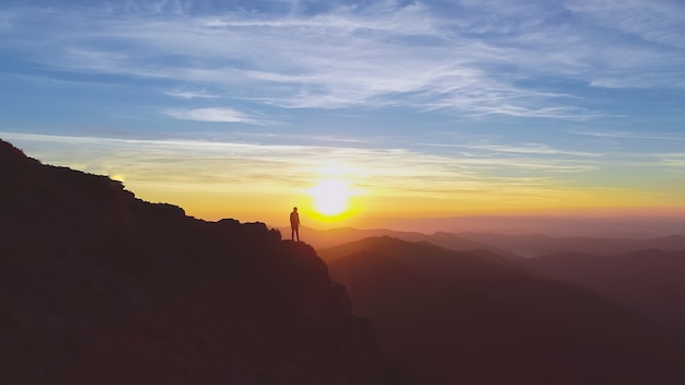 Premium Photo | The man standing on the mountain on the beautiful ...