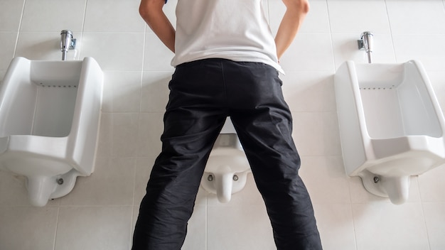 Premium Photo | Man standing pee in public toilet