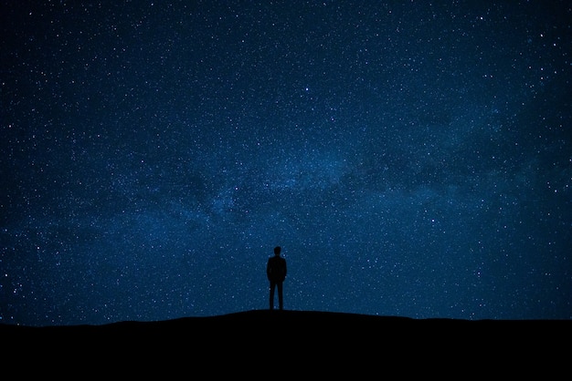 Premium Photo | The man standing on the starry sky background