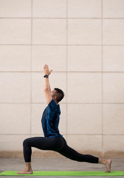 Free Photo | Man stretching outside while doing yoga