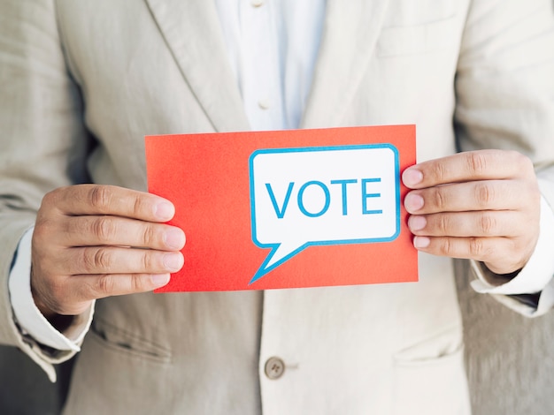 Free Photo | Man in suit holding a voting message