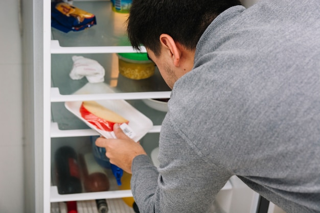 Man taking cheese from refrigerator Free Photo