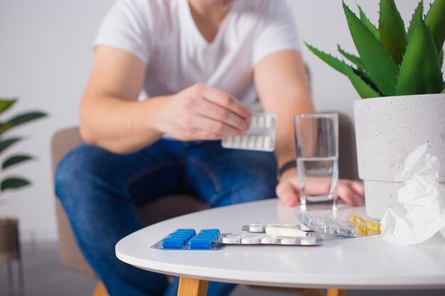 Man taking his pills on couch in the living room Premium Photo