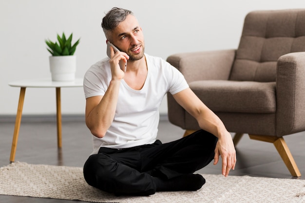 Free Photo | Man talking on the phone and sitting on the floor