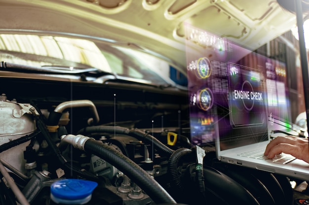 Man use laptop to analysis on his car engine with hologram. the concept of engine service hologram communication, network, insurance Premium Photo