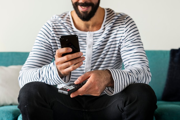 Man using device on couch Free Photo