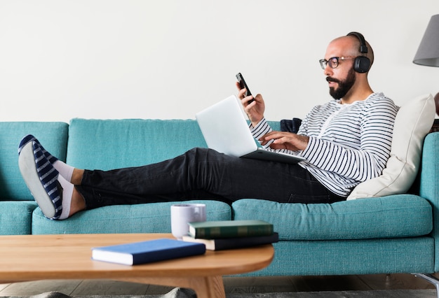 Man using device on couch Premium Photo