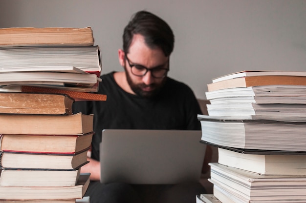 Free Photo | Man using laptop near books