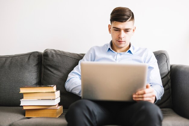 Man using laptop on sofa | Free Photo