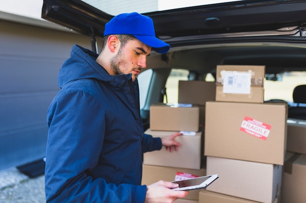 Man using tablet and delivering boxes Free Photo Man using tablet and delivering boxes Free Photo