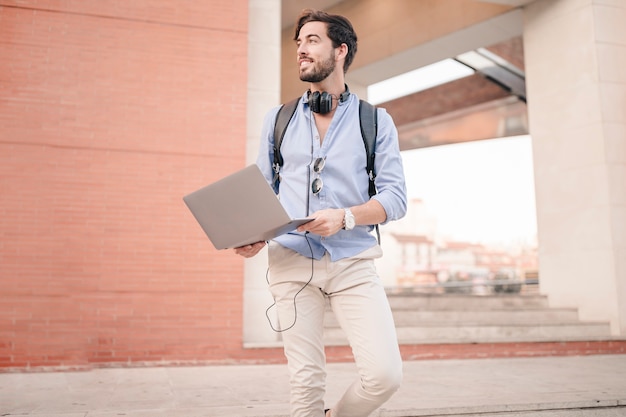 Free Photo | Man walking down staircase with laptop