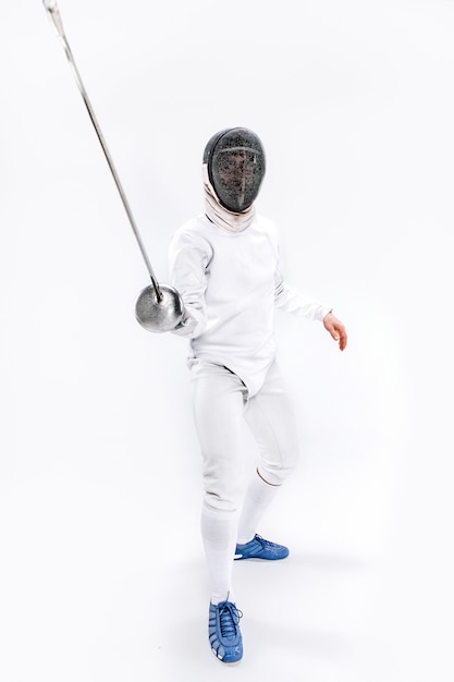 Free Photo | Man wearing fencing suit practicing with sword against gray