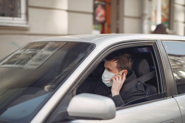 Free Photo | Man wearing a protective mask sitting in a car