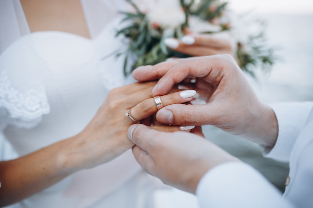 Premium Photo | A man wearing a wedding ring on his wife's finger.