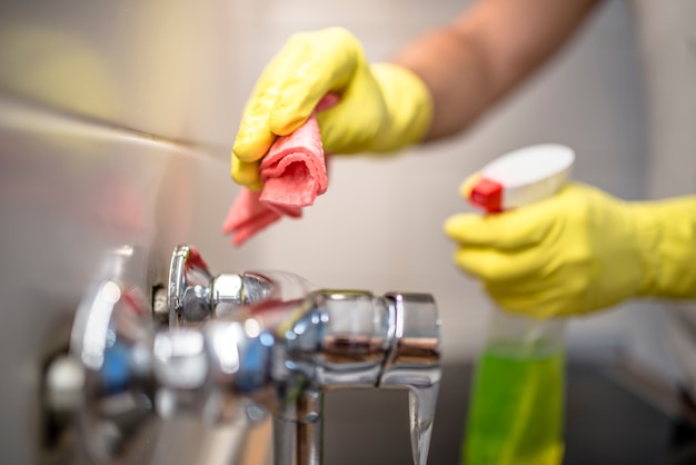 Premium Photo | Man wiping faucet in kitchen.