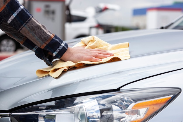 Premium Photo | The man wiping his car after washing in the car wash