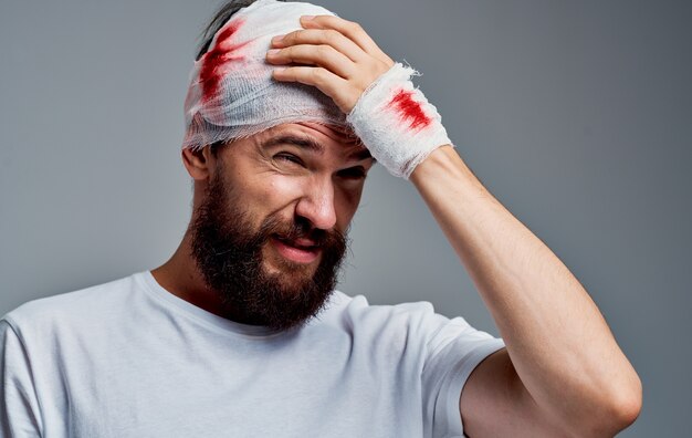 Premium Photo Man With Bandaged Head And Blood Concussion Gray Background Medicine