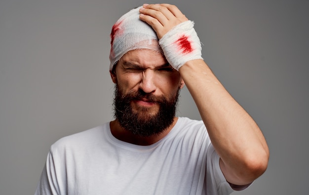 Premium Photo A Man With A Bandaged Head Blood On His Arm Operation Gray Background White T Shirt