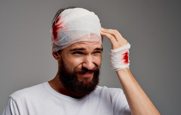 Premium Photo A Man With A Bandaged Head Blood On His Arm Operation Gray Background White T Shirt