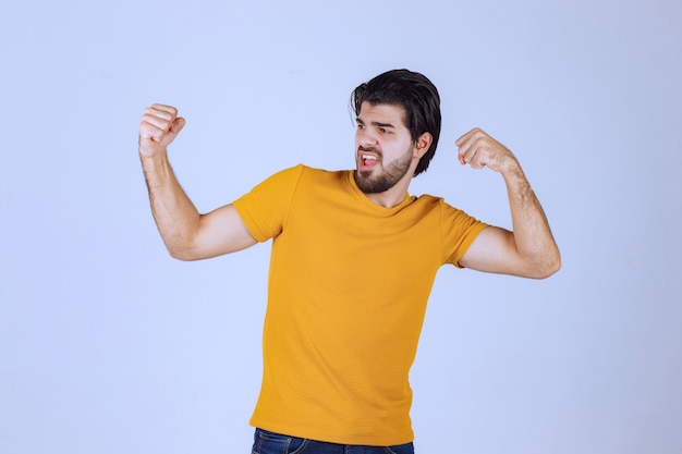 Free Photo | Man with beard demonstrating his fist and arm muscles and ...