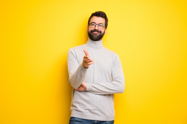 Man with beard and turtleneck shaking hands for closing a good deal Premium Photo