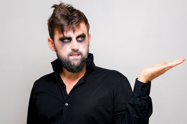 Premium Photo | A man with a beard and undead makeup on halloween holds ...