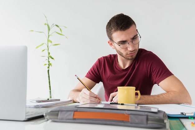 Man with glasses being focused white reading a paper Free Photo