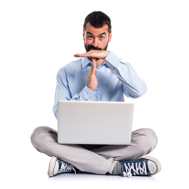 Man with laptop making time out gesture Free Photo