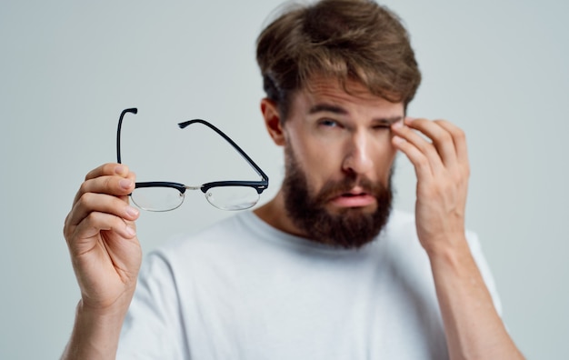 Premium Photo | A man with narrowed eyes holds glasses in his hand on a ...