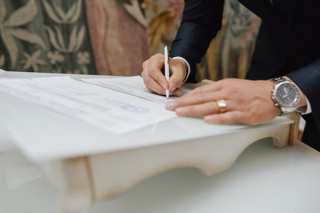 Man with a pen signs a document Free Photo