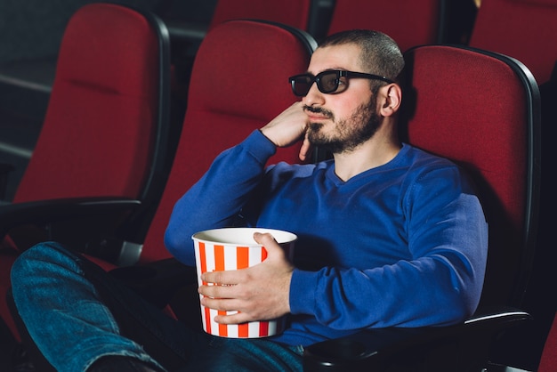 Man with popcorn in cinema auditorium | Free Photo