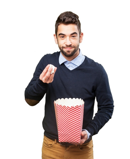 Man with popcorn in one hand and a package in the other ...